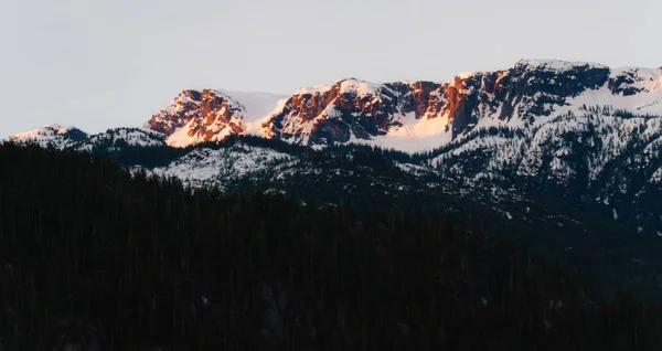 Vista mattutina sulle montagne innevate mentre sorge il sole — Foto Stock