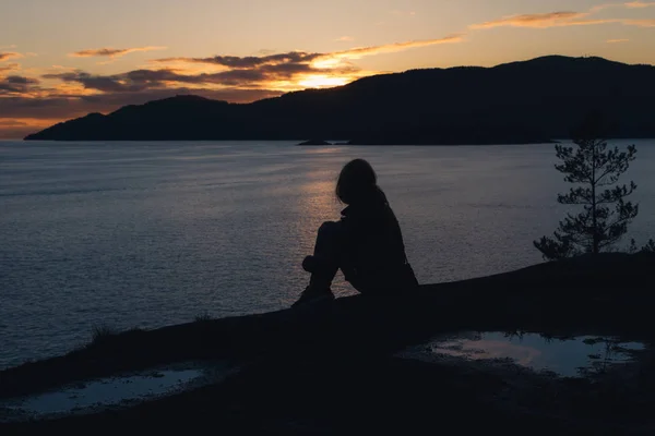 海と太陽、山と海岸の女性のシルエット — ストック写真