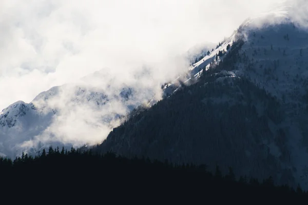 Zmrazené zimní krajina s velké hory pokryta mraky a — Stock fotografie