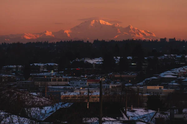 Dağlarda kar önünde günbatımı veya gündoğumu sırasında bina ile