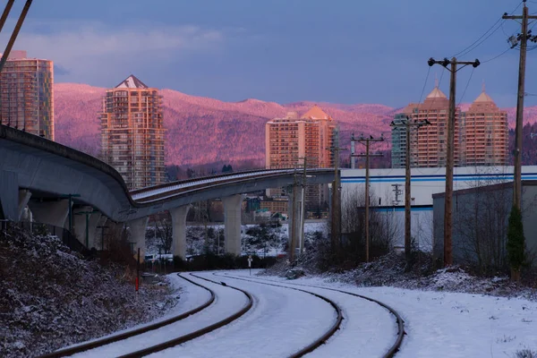 Ferrocarril vacío en la ciudad mientras colorido atardecer en invierno — Foto de Stock