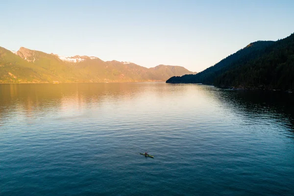 Vue aérienne du kayakiste sur le lac avec des montagnes au coucher du soleil — Photo