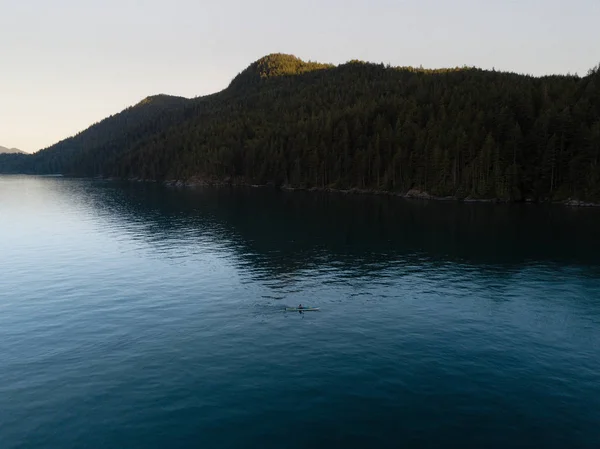 Colpo aereo di kayaker sul lago con le montagne durante il tramonto — Foto Stock