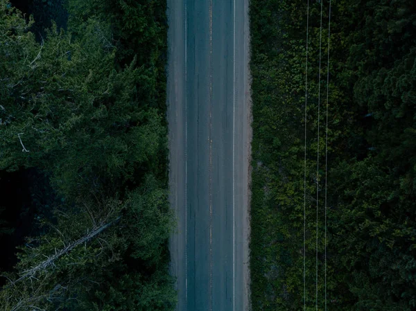 Tiro aéreo de estrada no vale enquanto o pôr do sol atrás da montanha Fotos De Bancos De Imagens Sem Royalties