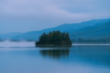 Sonbahar boyunca gün doğumu Alaska 'daki gölün yansımalarıyla