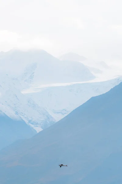 Plane flying in remote mountains in Alaska — Stock Photo, Image