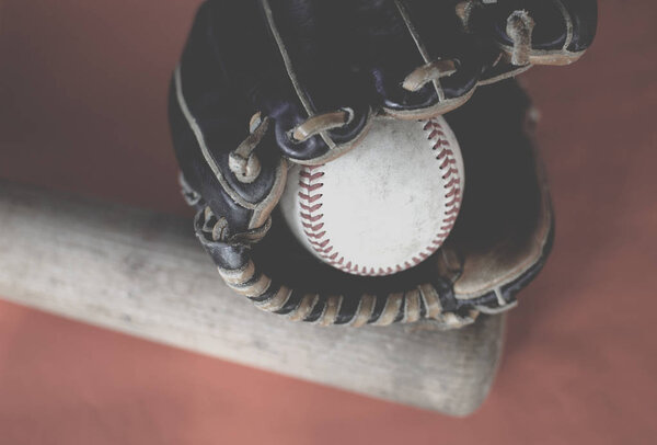 Кожаная перчатка держит мяч бейсбольной битой
.