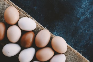 Organic chicken eggs background with copy space by burlap.