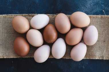 Farm fresh chicken eggs in arrangement on burlap background.