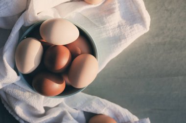 Rustic chicken eggs concept with copy space, flat lay in bowl.