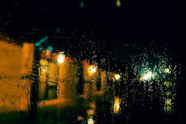 Bardaktaki yağmur, yağmurlu havada geceleri bina inşa ettiğini gösteriyor..