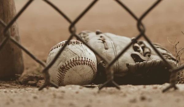Close up of baseball glove with ball on sports field.