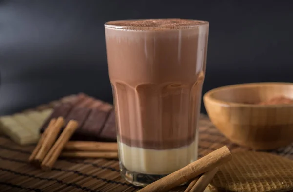 Вкусный горячий шоколад в стакане с корицей — стоковое фото