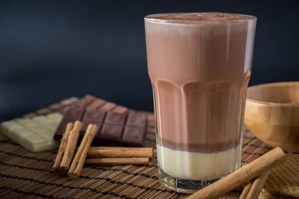 Heerlijke warme chocolademelk in een glas met kaneel. — Stockfoto