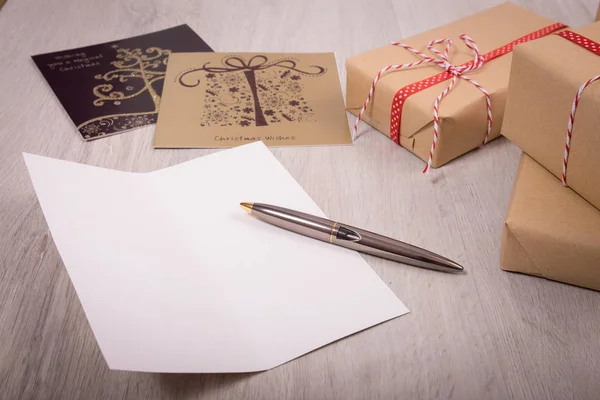 Presente de Natal e cartão de Natal aberto branco sobre um fundo de madeira — Fotografia de Stock