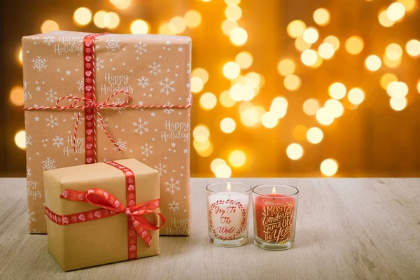 Presente de Natal e velas sobre um fundo de madeira — Fotografia de Stock