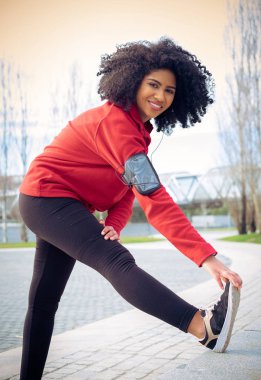 Earphones ile çalıştırmadan önce güzel sporcu kadın streaching
