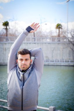 Genç sporcu adam parkta çalıştırmadan önce ısınma