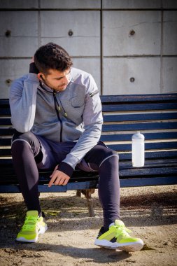 Genç sporcu adam parkta çalıştırdıktan sonra dinlenme