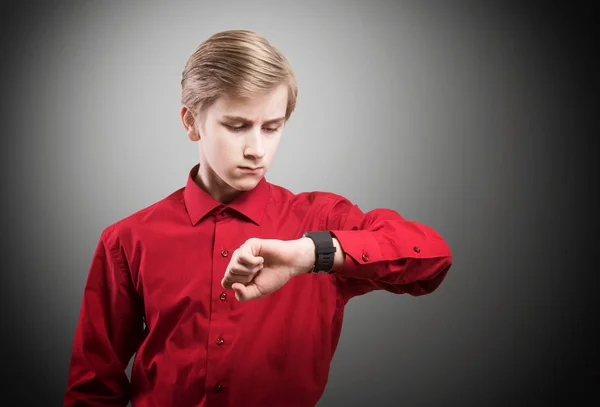 Nastolatek, patrząc na jego zegarek na rękę. — Zdjęcie stockowe