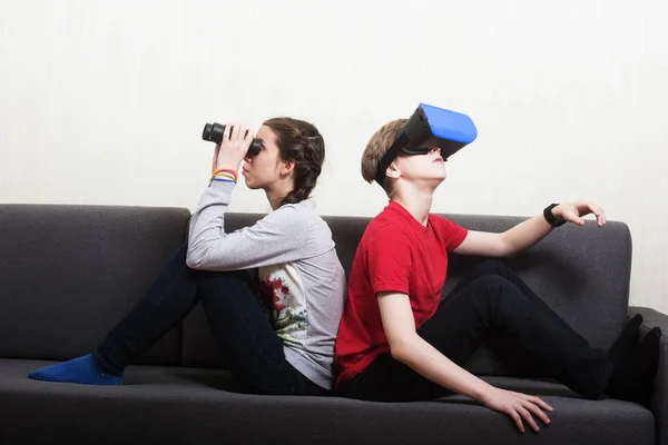 Chica joven mirando a fondo el binocular y el niño vistiendo vi — Foto de Stock