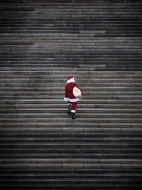 Santa claus climbing stairs. Present delivery concept . clipart