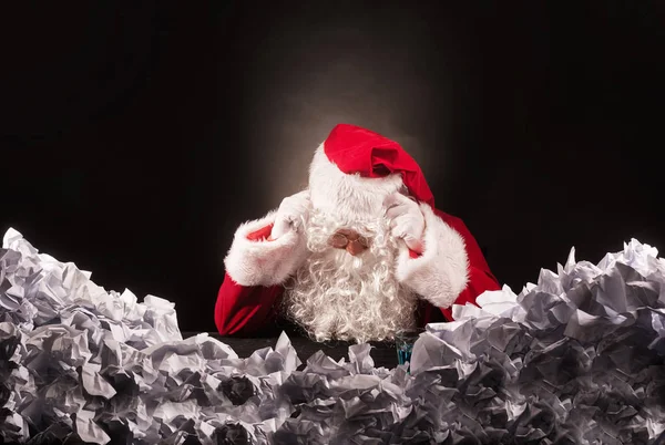 Santa klausul med en stor hög av skrynkligt papper. — Stockfoto