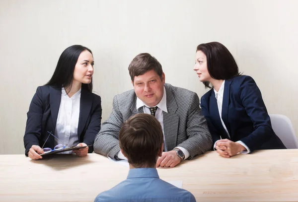 Ung man under anställningsintervju och medlemmar av managemen — Stockfoto