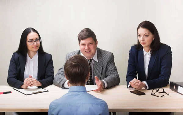 Ung man under anställningsintervju och medlemmar av managemen — Stockfoto