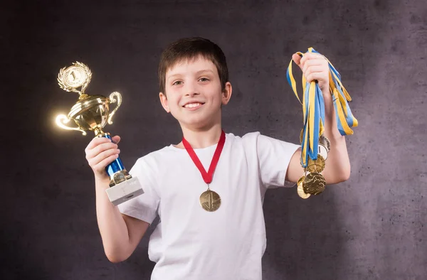Mały chłopiec obchodzi jego złote trofeum — Zdjęcie stockowe