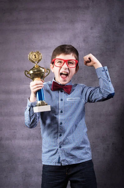 Kleiner Junge feiert seinen goldenen Pokal — Stockfoto