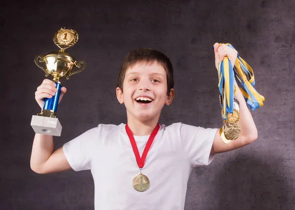 Kleiner Junge feiert seinen goldenen Pokal — Stockfoto