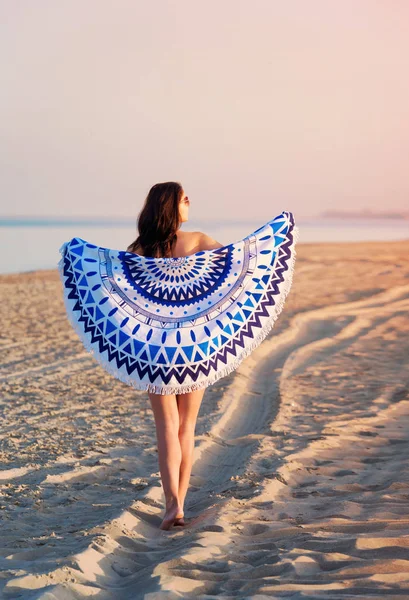 Mujer bonita con un tapiz de playa redonda mandala en el océano co — Foto de Stock