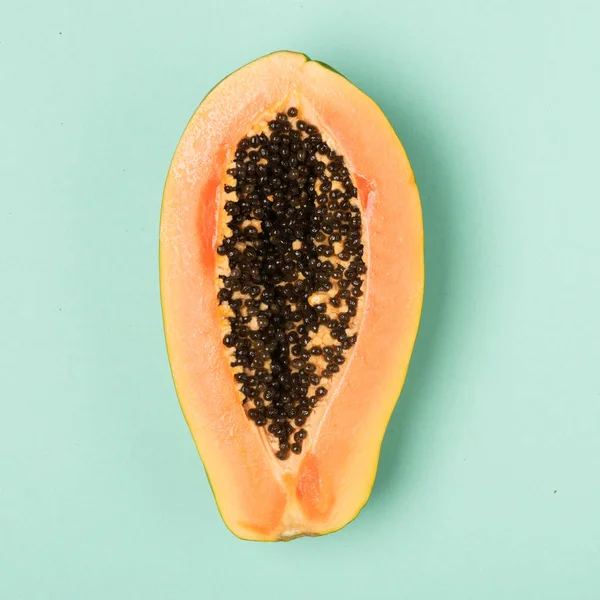 Färsk papaya isolerad på mynta bakgrund. Platt liggstil. Stockfoto