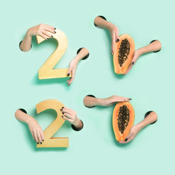 Kadın elleri, yeni yıla ait altın 2020 haneli rakamları ve papayaları neon arkaplanda bir delikten tutuyor. Asgari yaratıcı xmas izole konsept. — Stok fotoğraf