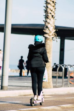 Tel Aviv İsrail 28 Şubat 2020 'de güneşli bir kış gününde Tel Aviv sokaklarında elektrikli scooterla dolaşan kimliği belirsiz insanların görüntüsü