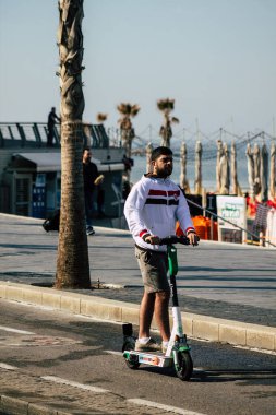 Tel Aviv İsrail 28 Şubat 2020 'de güneşli bir kış gününde Tel Aviv sokaklarında elektrikli scooterla dolaşan kimliği belirsiz insanların görüntüsü