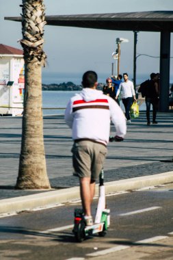 Tel Aviv İsrail 28 Şubat 2020 'de güneşli bir kış gününde Tel Aviv sokaklarında elektrikli scooterla dolaşan kimliği belirsiz insanların görüntüsü
