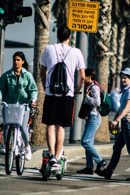 Tel Aviv İsrail 28 Şubat 2020 'de güneşli bir kış gününde Tel Aviv sokaklarında elektrikli scooterla dolaşan kimliği belirsiz insanların görüntüsü