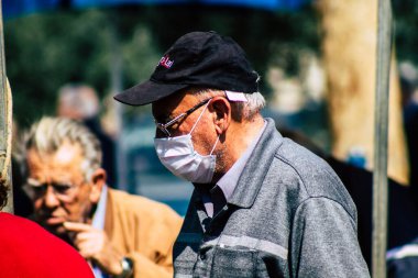 Limasol Kıbrıs Rum Kesimi 14 Mart 2020 'de kendilerini sabah Limasol pazarından koronavirüs alışverişinden korumak için maske takan kimliği belirsiz insanların görüntüsü
