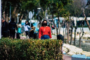 Limasol Kıbrıs Rum Kesimi 16 Mart 2020 öğleden sonra Limasol caddesinde yürüyen koronavirüsten kendilerini korumak için maske takan kimliği belirsiz insanların görüntüsü