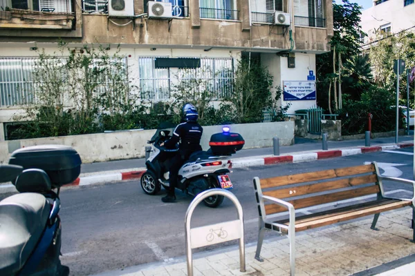 Tel Aviv İsrail, 12 Nisan 2020. Coronavirus 'un yayılmasını önlemek için Tel Aviv sokaklarında scooterla dolaşan bir İsrail polisinin görüntüsü.