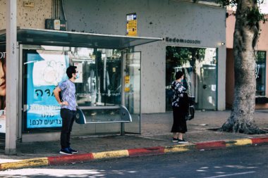Tel Aviv İsrail 26 Nisan 2020 öğleden sonra Dizengoff caddesindeki otobüs durağında Coronavirus salgını sırasında kimliği belirsiz insanların görüntüsü