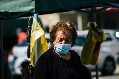 Kıbrıs Rum Kesimi 23 Mayıs 2020 'de, kendilerini sabah Limasol pazarındaki koronavirüsten korumak için maske takan kimliği belirsiz insanların portresi.