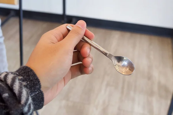 Sol bir kaşık tutan el