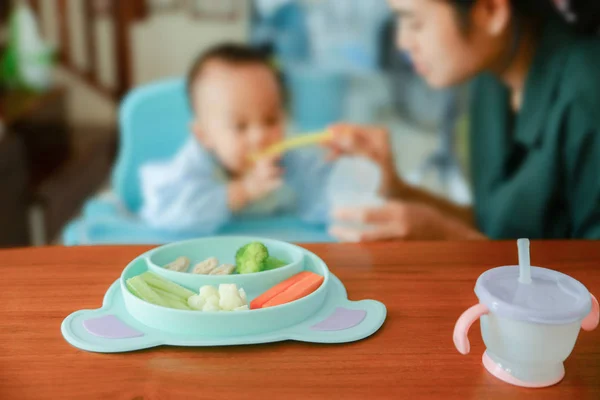 Happy eating Asian baby boy, 7 months old eating with Baby Led W