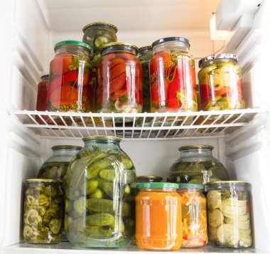 Buzdolabındaki cam kavanozlarda konserve sebzeler.