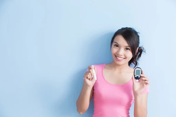 Mujer sosteniendo un glucómetro — Foto de Stock