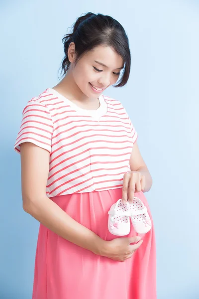 Zwangere vrouw bedrijf schoenen — Stockfoto