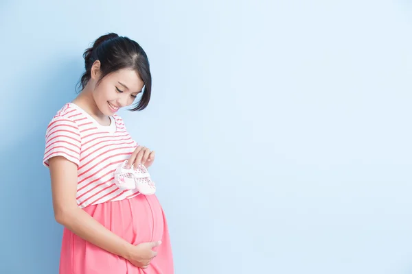 Беременная женщина берет обувь — стоковое фото